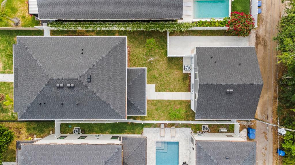 An aerial view shows three houses with dark shingled roofs, two swimming pools, and grassy yards — 320 43RD AVENUE N, ST PETERSBURG, FL