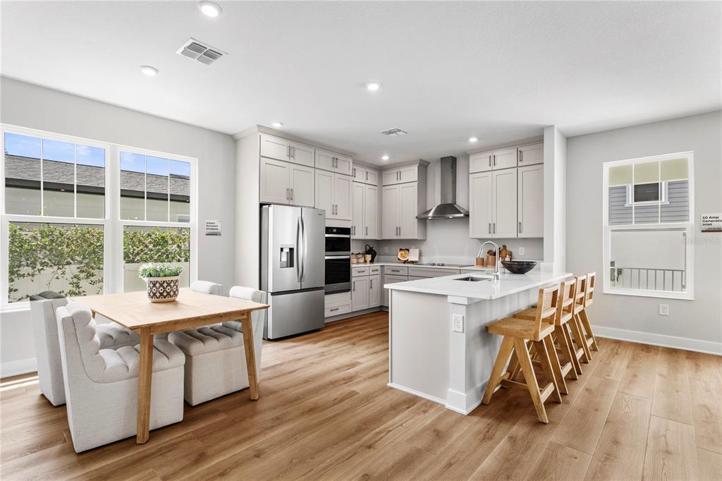 A modern kitchen features light gray cabinetry, stainless steel appliances, a center island, and wood flooring — 320 43RD AVENUE N, ST PETERSBURG, FL