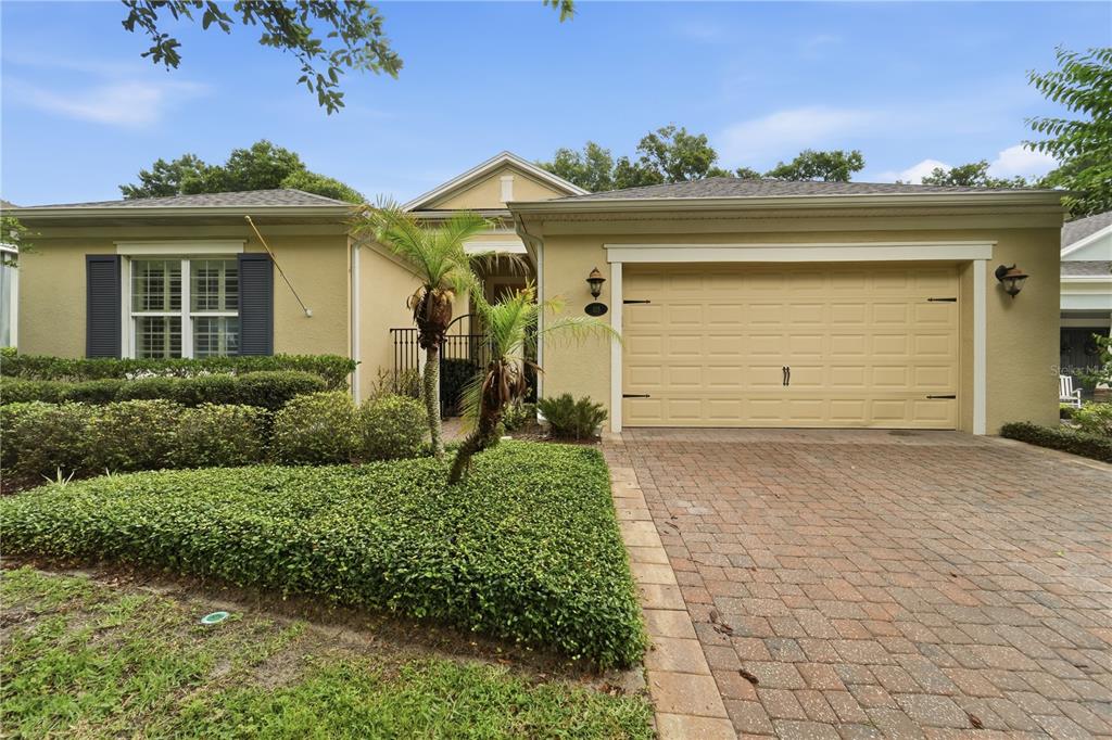 A covered outdoor dining area features a glass table, chandelier, and a view of a patio — 125 ASTERBROOKE DRIVE, DELAND, FL