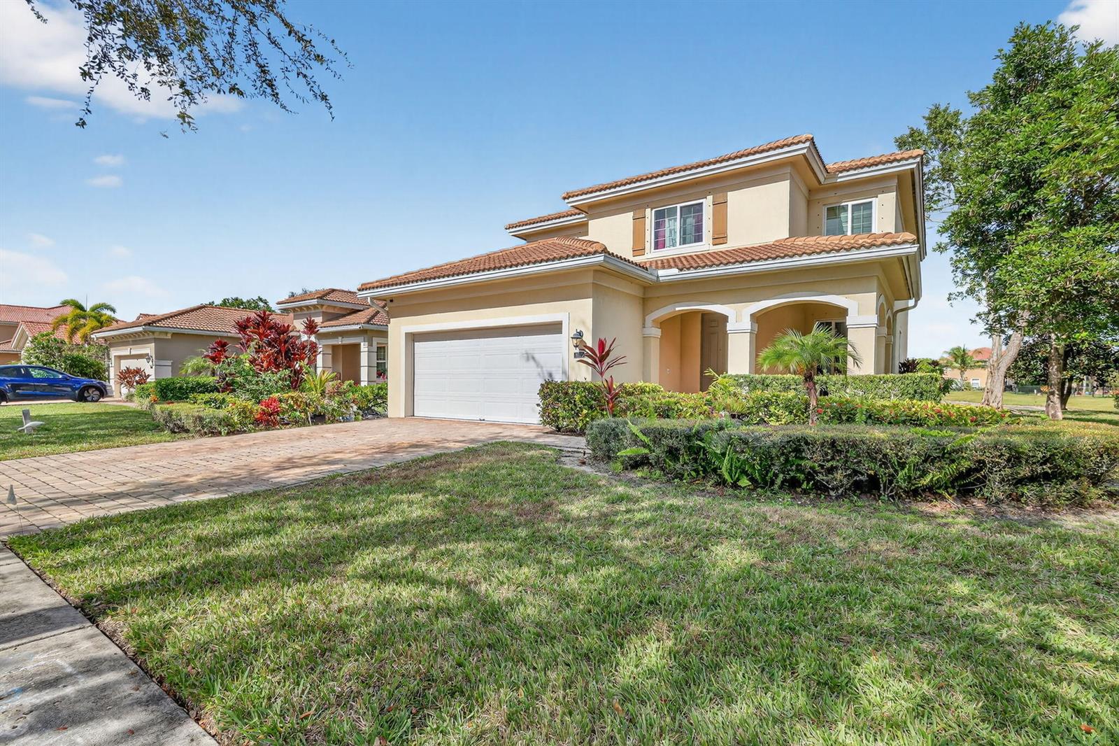 A two-story tan stucco house with a tile roof and a paved driveway — 6720 Osage Circle, FL 33413, FL