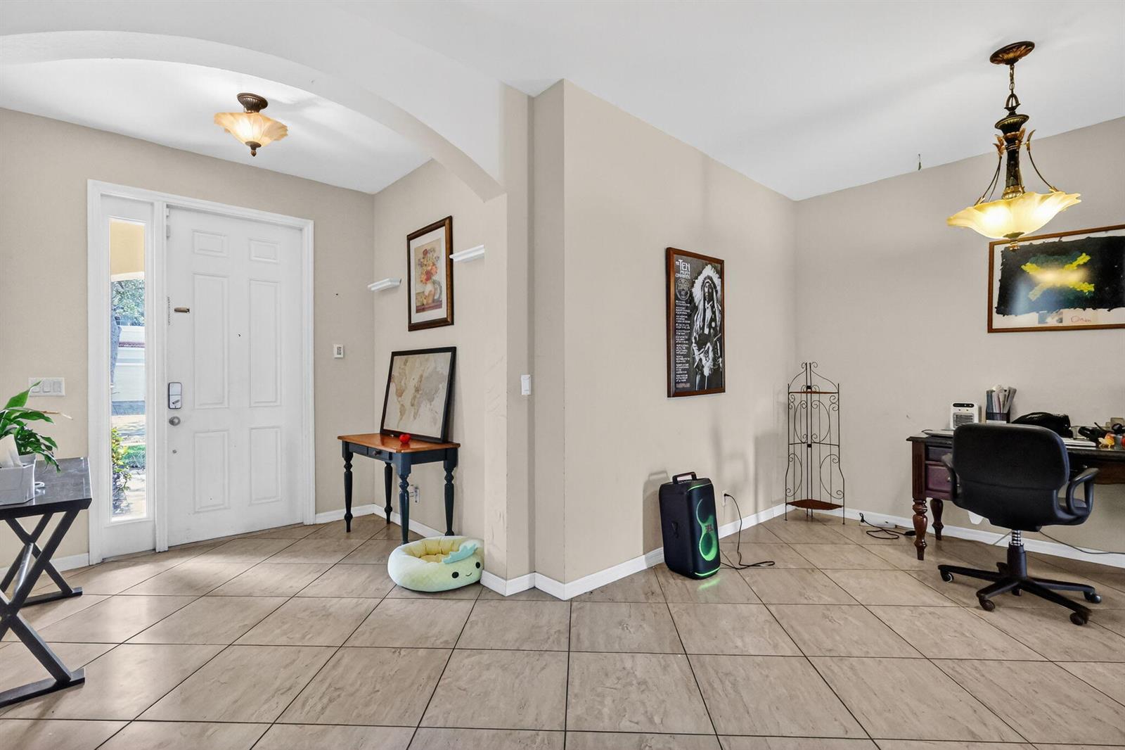 A tiled entryway leads into an office area featuring a desk, chair, and decorative lighting — 6720 Osage Circle, FL 33413, FL