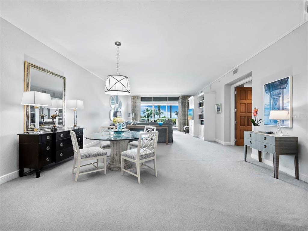 A dining area with a glass table and chairs opens into a living room with views — 2185 GULF OF MEXICO DRIVE UNIT 212, LONGBOAT KEY, FL