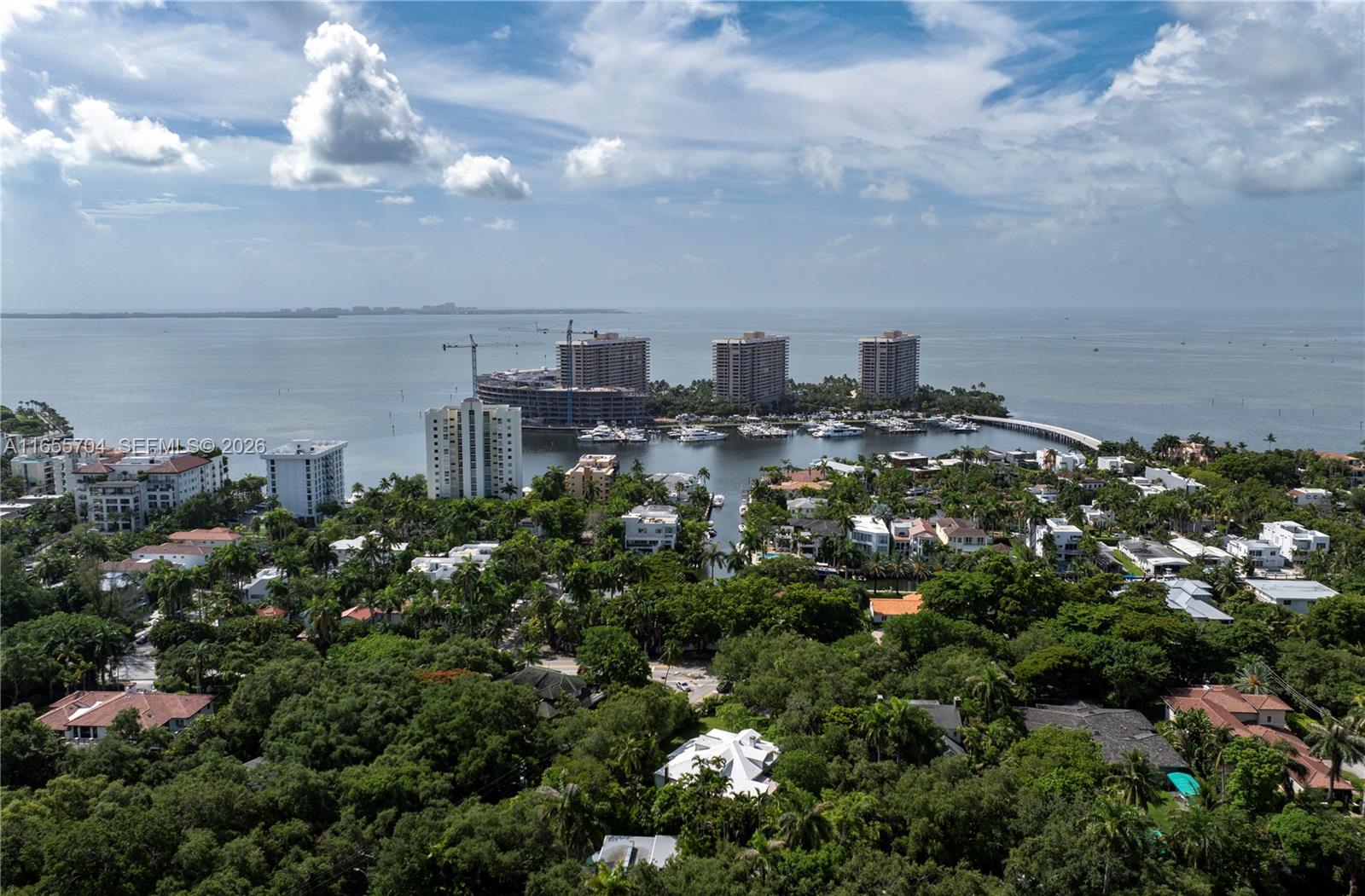 An aerial view shows a coastal residential area with high-rise buildings, a marina, and dense trees — 1701 S Bayshore Drive, Miami FL 33133, MIAMI, FL