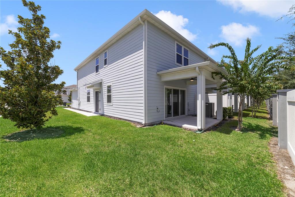 The exterior of a two-story house with light gray siding, a covered patio, and lawn — 2857 CLEVER LANE, WINTER PARK, FL