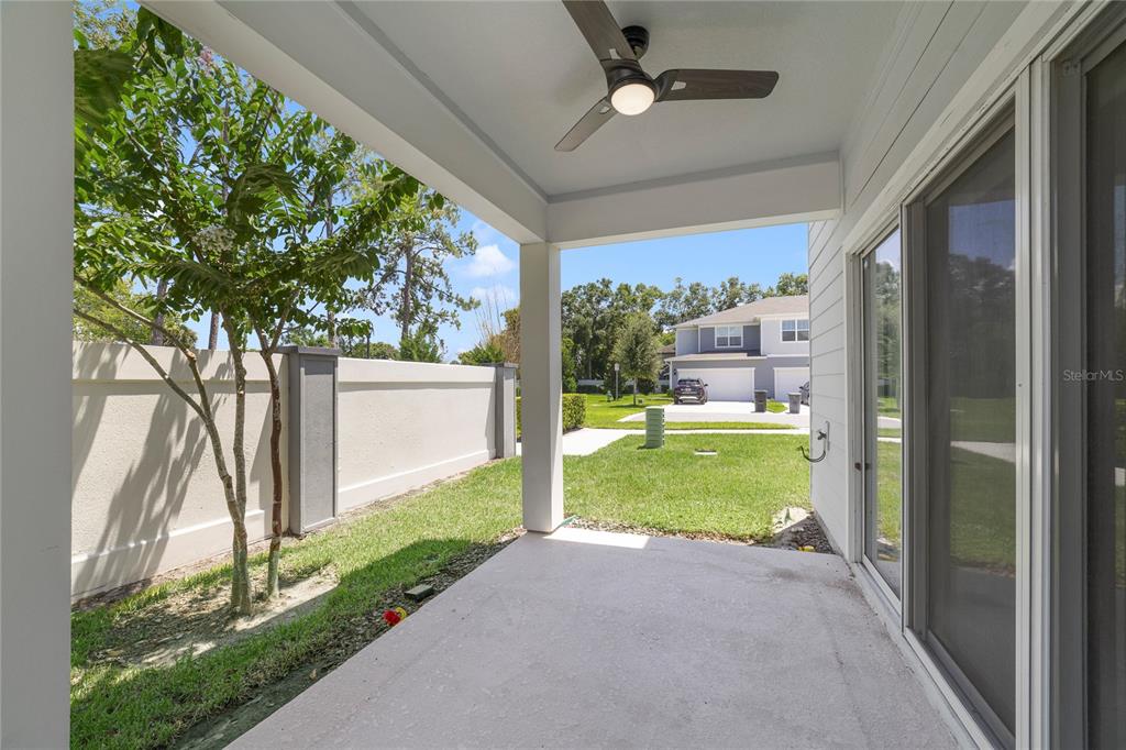 A covered concrete patio overlooks a grassy yard and a neighboring house — 2857 CLEVER LANE, WINTER PARK, FL