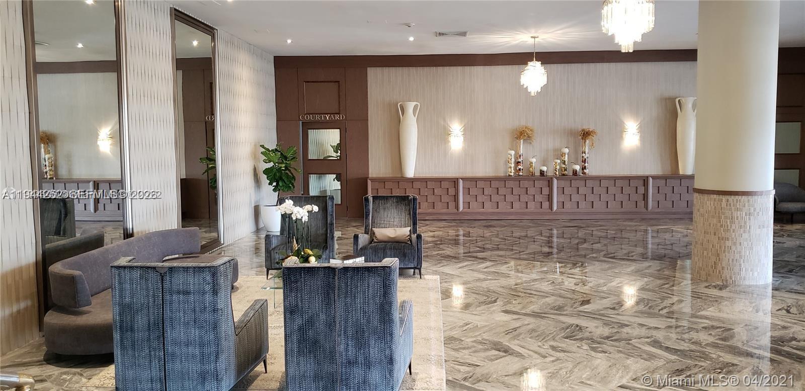 A spacious lobby features marble floors, plush seating, decorative vases, and a courtyard entrance — 5401 SE Collins Ave # 1412, Miami Beach FL 33140, MIAMI BEACH, FL