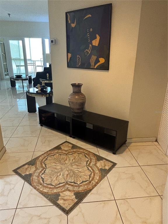 An entryway features a decorative tile inlay, a black console table, and abstract wall art — 2333 FEATHER SOUND DRIVE UNIT C107, CLEARWATER, FL