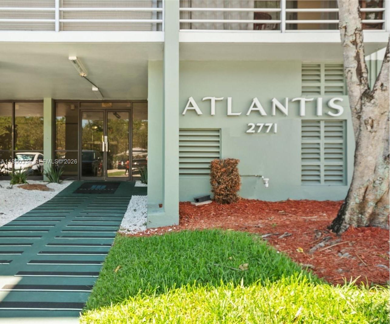 The exterior of a building features a green wall with the name Atlantis and address — 2771 Taft St # 411, Hollywood FL 33020, HOLLYWOOD, FL