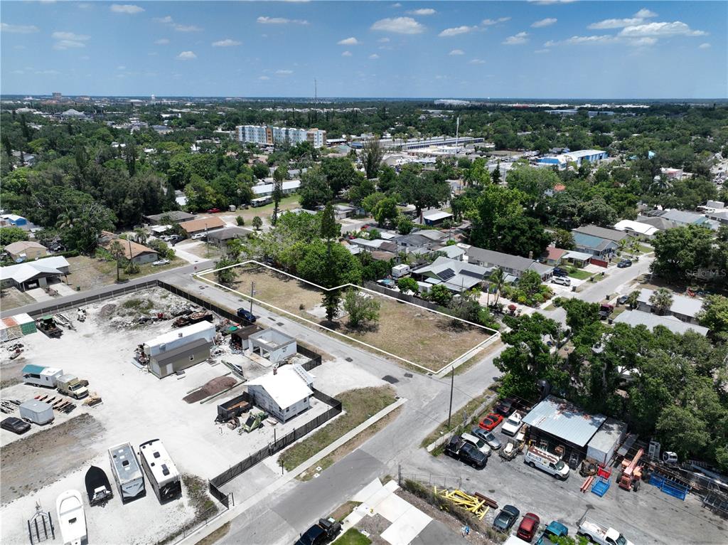 An aerial view shows a vacant rectangular lot surrounded by residential and commercial properties — 1206 27TH AVENUE W, BRADENTON, FL