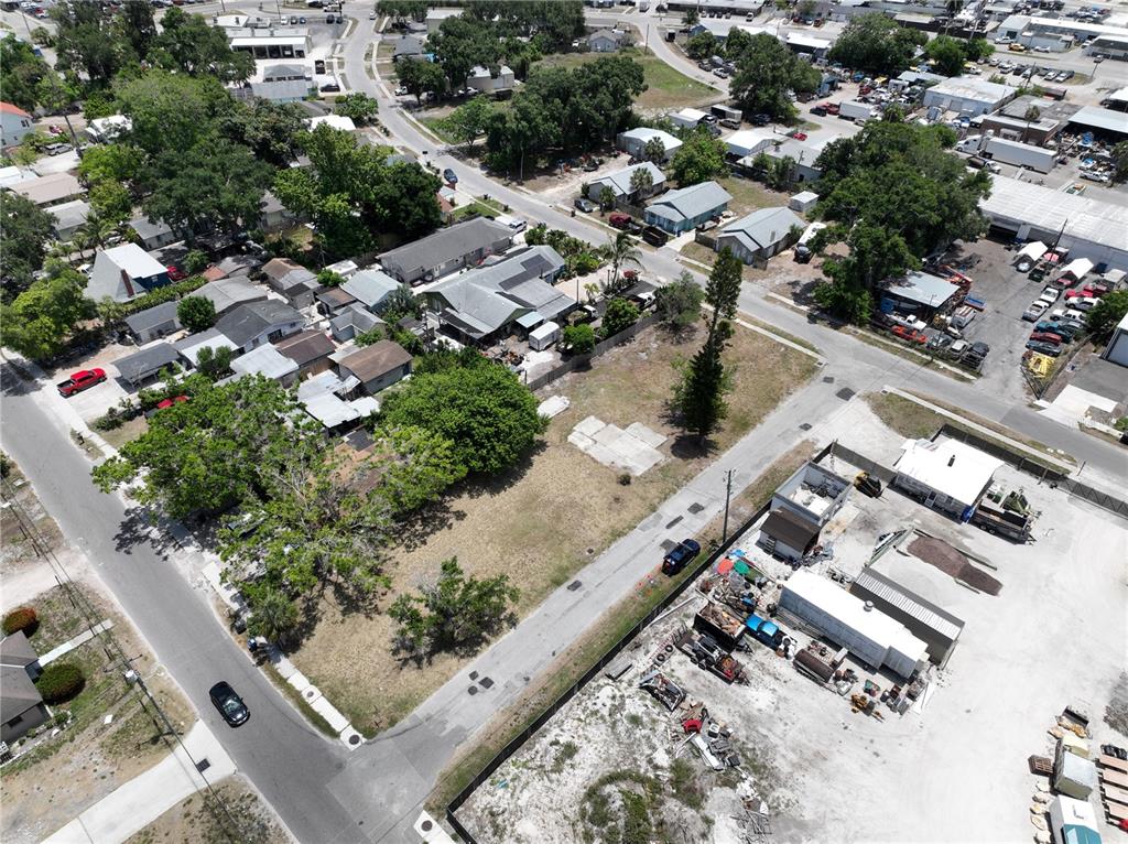 An aerial view shows a vacant lot situated between residential houses and an industrial area — 1206 27TH AVENUE W, BRADENTON, FL