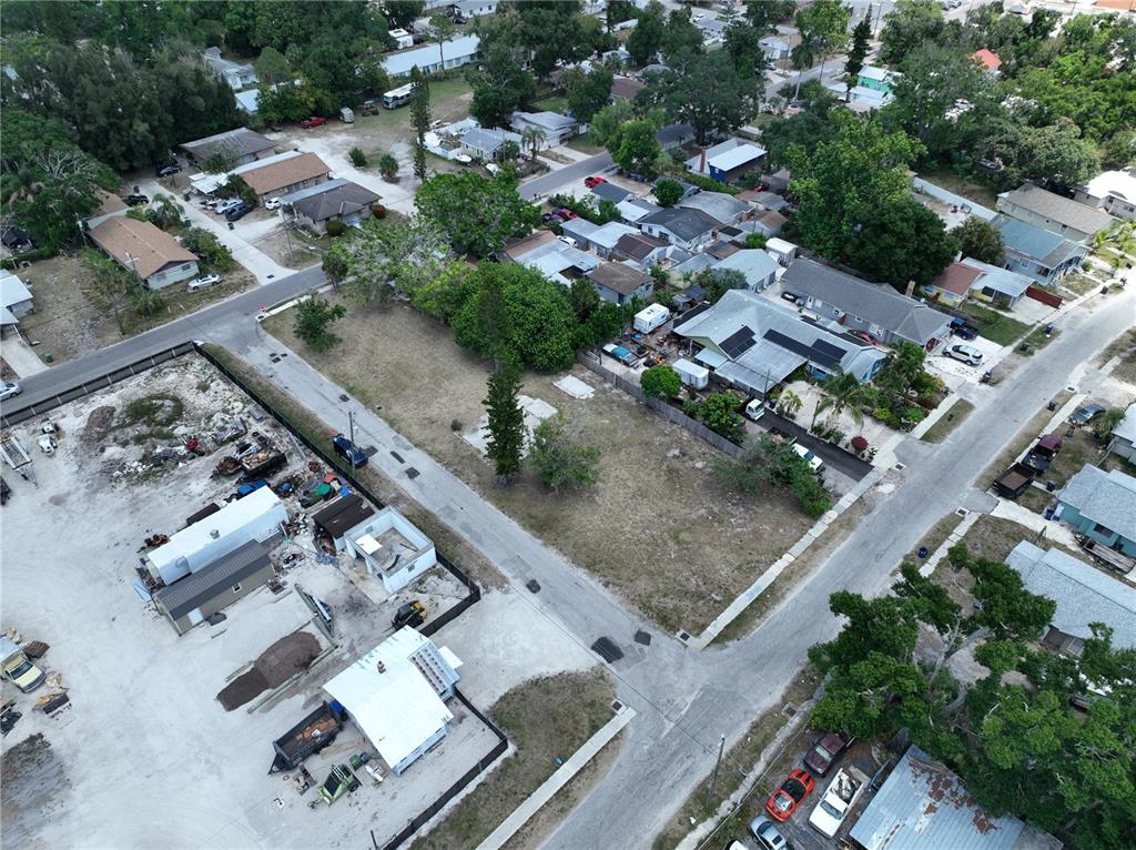 An aerial view shows a vacant lot surrounded by residential houses and commercial properties — 1206 27TH AVENUE W, BRADENTON, FL