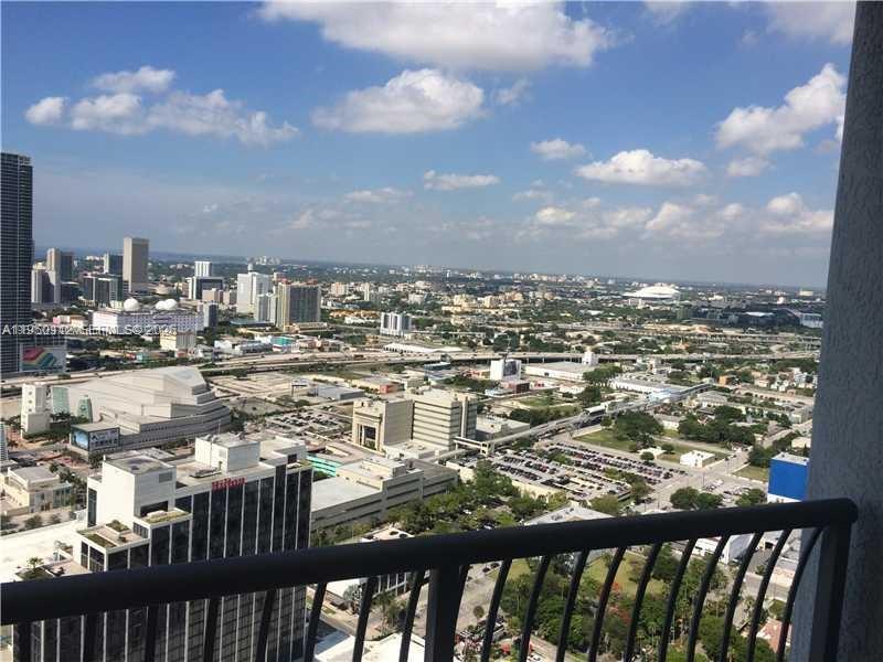 A high-angle view of a city skyline seen from a balcony with a metal railing — 1750 N Bayshore Dr # 4912, Miami FL 33132, MIAMI, FL