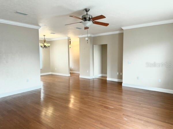 An open-concept living area features hardwood floors, a ceiling fan, and neutral-colored walls — 8992 SW 79TH AVENUE, GAINESVILLE, FL