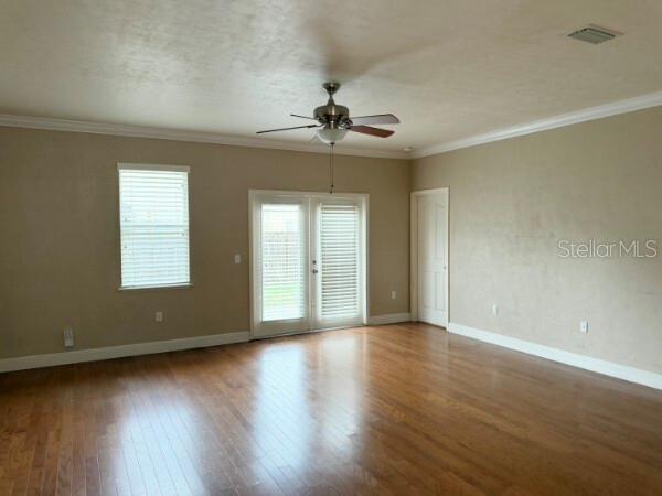 An empty room with hardwood floors, a ceiling fan, and glass doors leading outside — 8992 SW 79TH AVENUE, GAINESVILLE, FL