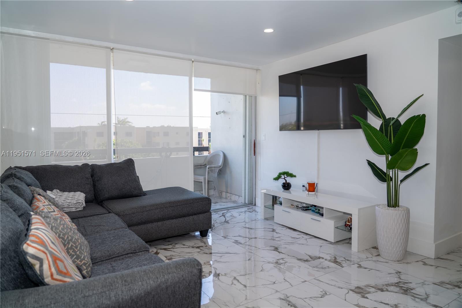 A living room features a gray sectional sofa, white media console, and marble-patterned tile flooring — 854 NW 87th Ave # 405, Miami FL 33172, MIAMI, FL