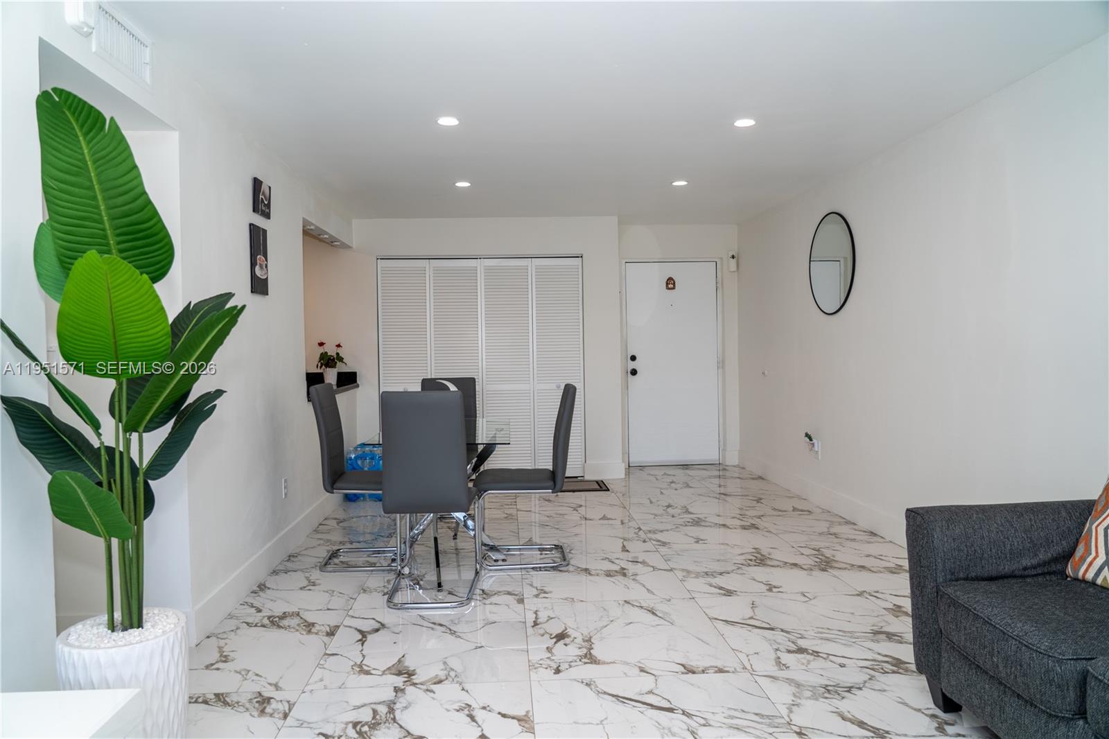 A dining area features a glass table, grey chairs, and white marble-patterned tile flooring — 854 NW 87th Ave # 405, Miami FL 33172, MIAMI, FL