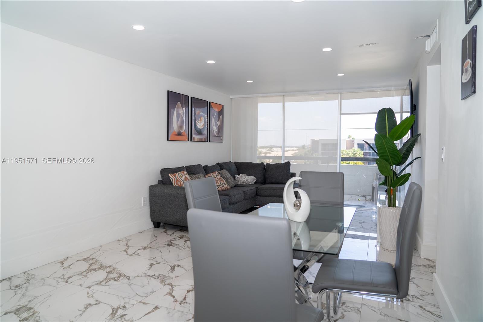 A living and dining area features marble floors, a grey sectional sofa, and glass table — 854 NW 87th Ave # 405, Miami FL 33172, MIAMI, FL