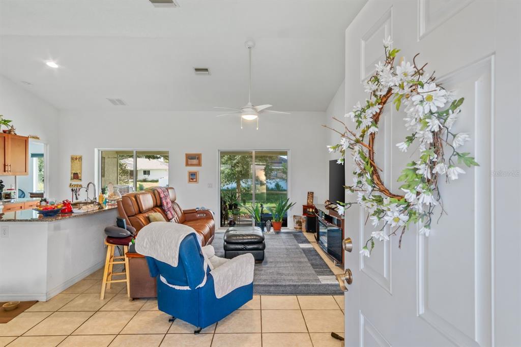 A view from an entryway into a living room with tile floors and a ceiling fan — 8232 WAWANA ROAD, NORTH PORT, FL