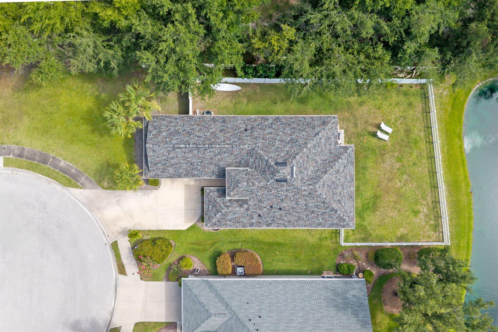 An aerial view shows a house with a shingled roof, a backyard, and a pond — 7005 56th Terrace E, FL 34221, FL