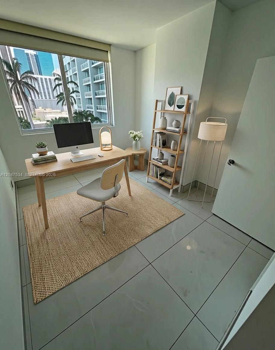 A home office features a wooden desk, a chair, a bookshelf, and a large window — 244 Biscayne Blvd # 1009, Miami FL 33132, MIAMI, FL