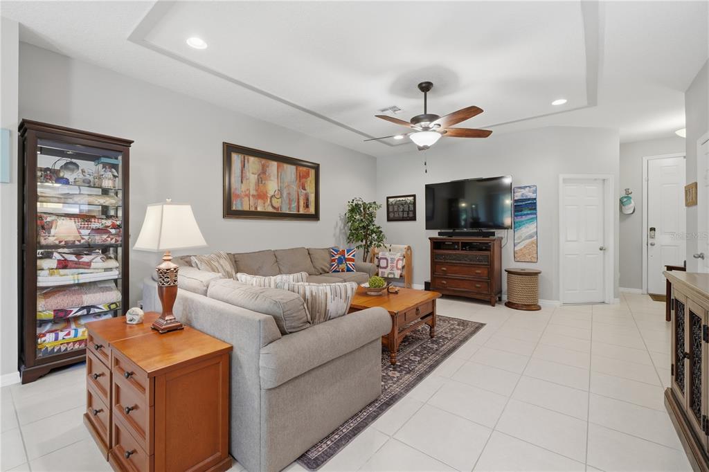 A living room features a grey sectional sofa, a wooden coffee table, and a television console — 4844 CLIVEDEN LOOP, SANFORD, FL