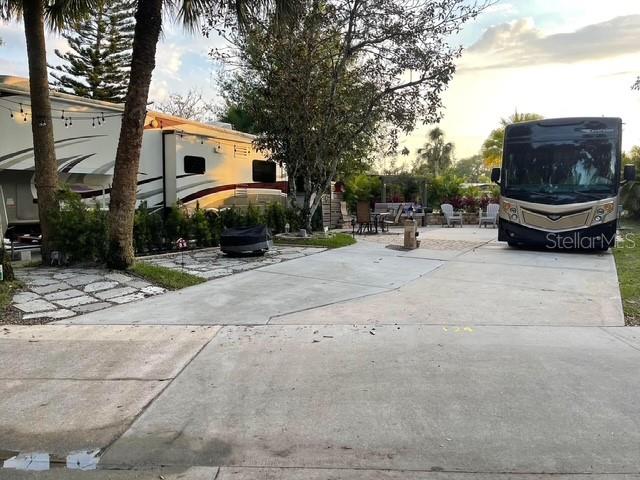A paved driveway features a large motorhome parked next to a fifth-wheel trailer — 124 STALLION LANE, LAKE WALES, FL
