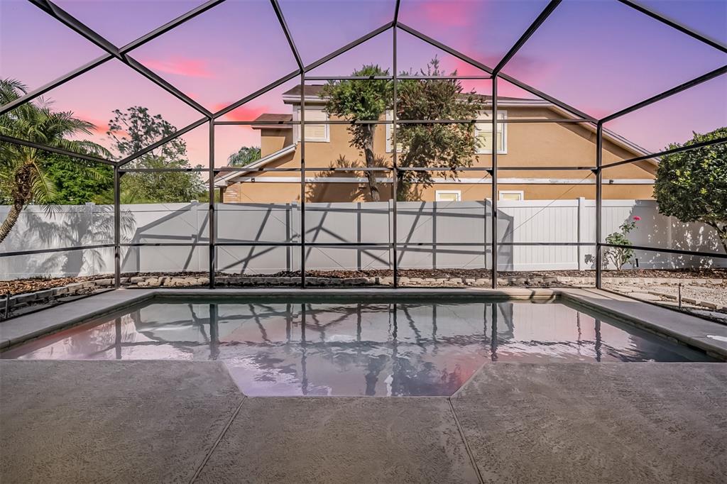A screened-in swimming pool with a concrete deck and a view of a neighboring house — 9008 QUAIL CREEK DRIVE, TAMPA, FL