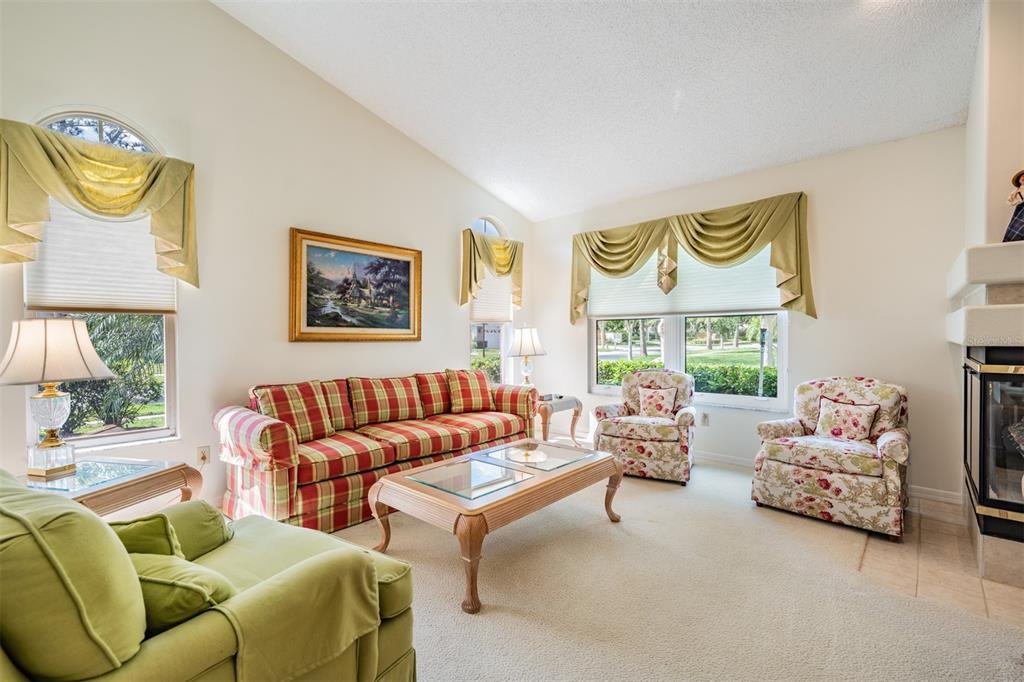 A living room features a plaid sofa, two floral armchairs, and a green armchair — 9008 QUAIL CREEK DRIVE, TAMPA, FL