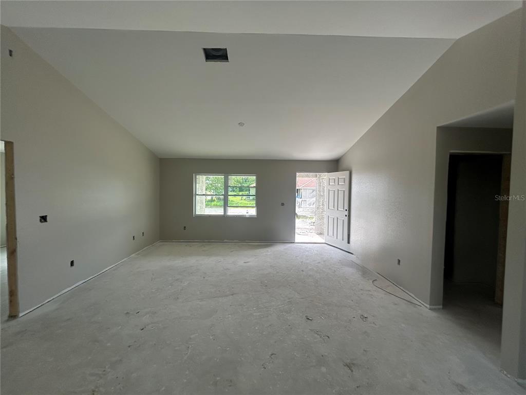 An unfinished room with gray walls, a vaulted ceiling, and a concrete floor — 11506 SW LEMON AVENUE, ARCADIA, FL