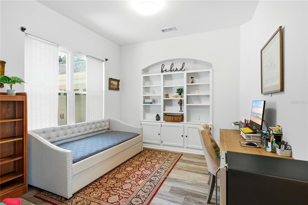 A home office features a daybed, a desk, and a white built-in bookshelf — 13706 VIA ROMA CIRCLE, CLERMONT, FL