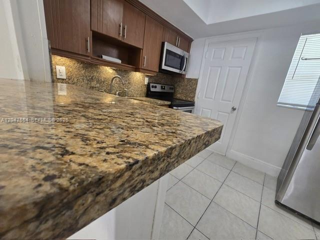 A kitchen features granite countertops, wood cabinets, and stainless steel appliances — 2441 NW 13th St # 62, Miami FL 33125, MIAMI, FL
