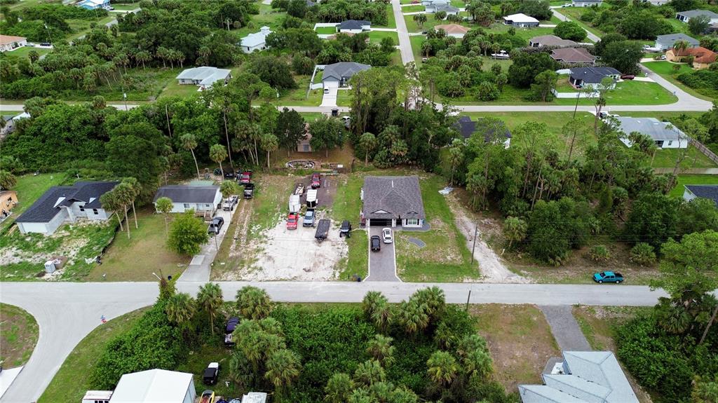 An aerial view shows two houses on a street surrounded by trees and vegetation — 3715 TEAKWOOD STREET, FORT MYERS, FL