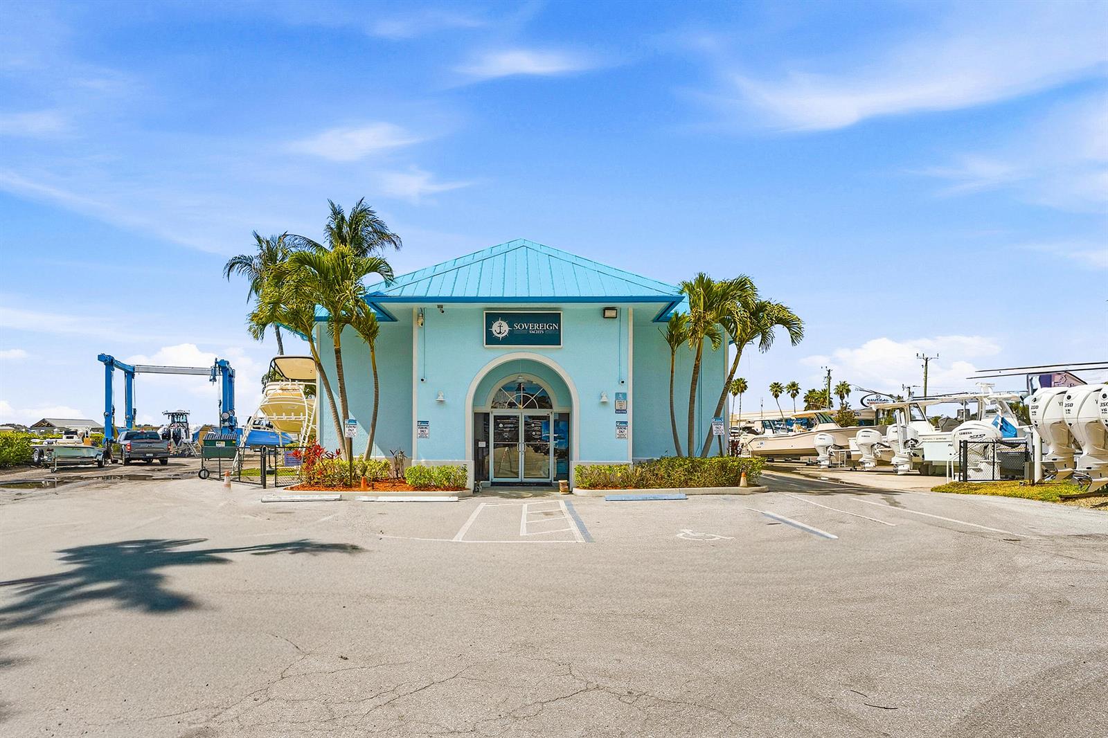 A light blue building with a metal roof stands in a parking lot with boats — 250 SW Monterey Road, Stuart FL 34994, STUART, FL