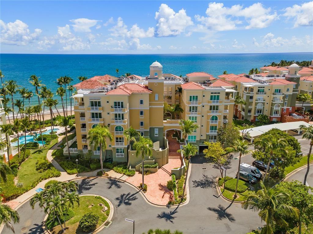 An aerial view of a multi-story yellow resort building with a red tile roof — 400 OCEAN DRIVE UNIT 453, HUMACAO, PR