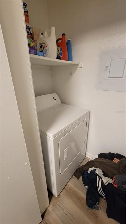 A laundry closet contains a white dryer, a storage shelf with cleaning supplies, and flooring — 4400 THORNBRIAR LANE UNIT 201, ORLANDO, FL