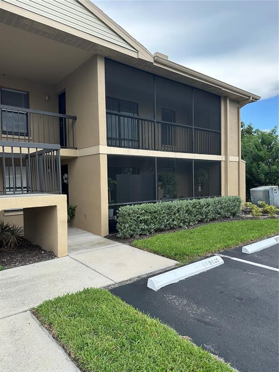 A two-story apartment building exterior features a concrete staircase, tan stucco walls, and screened balconies — 5331 SUMMERLIN ROAD UNIT 3112, FORT MYERS, FL