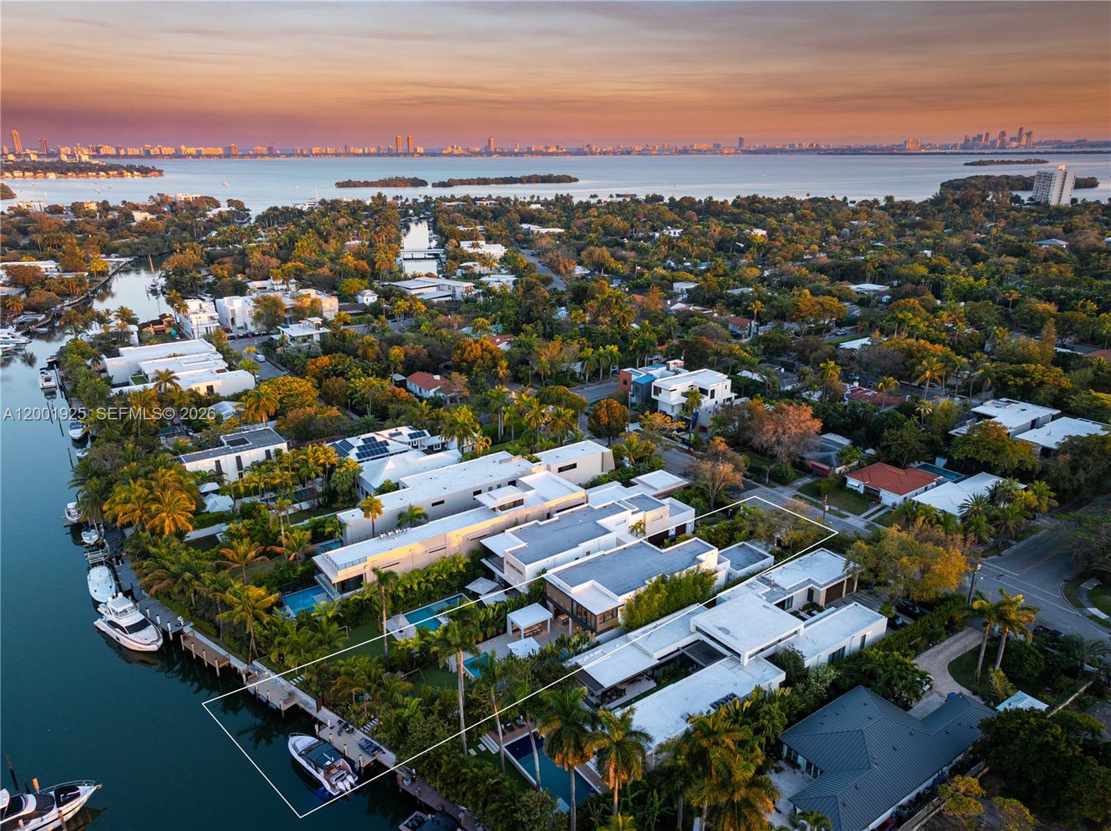 An aerial view shows a modern waterfront house with a pool and boat dock — 707 NE 77th St, Miami FL 33138, MIAMI, FL