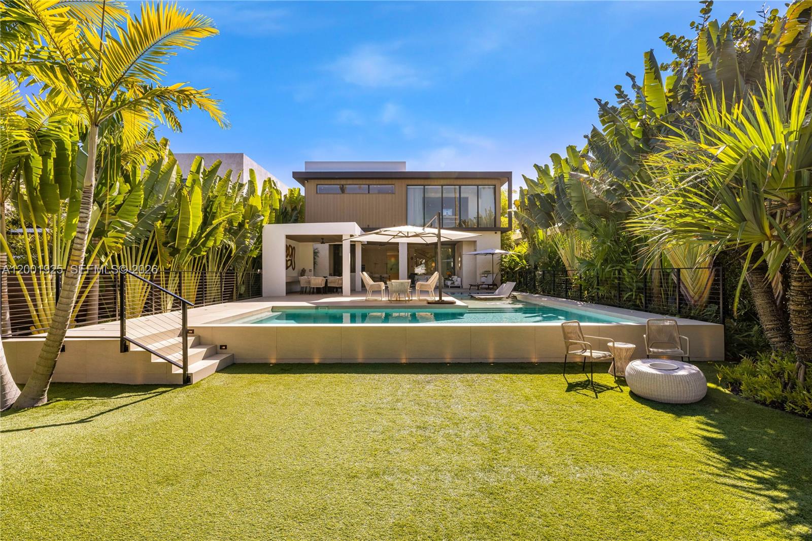 A modern two-story house features a backyard with a swimming pool and artificial turf lawn — 707 NE 77th St, Miami FL 33138, MIAMI, FL