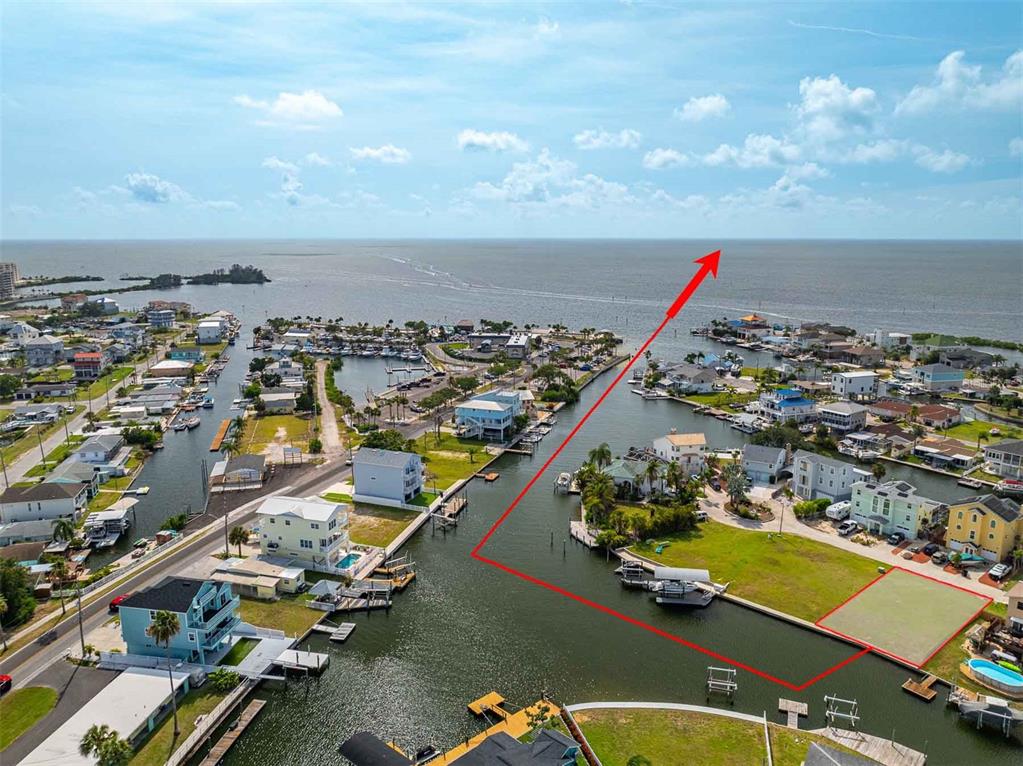 An aerial view shows a waterfront residential lot with a red outline and boat docks — 6520 LOUISE COURT, HUDSON, FL
