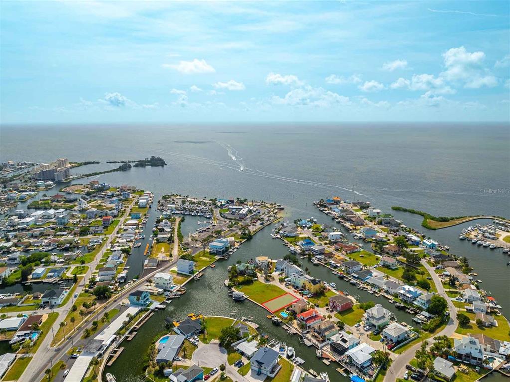 An aerial view shows a waterfront residential neighborhood with a highlighted vacant lot — 6520 LOUISE COURT, HUDSON, FL