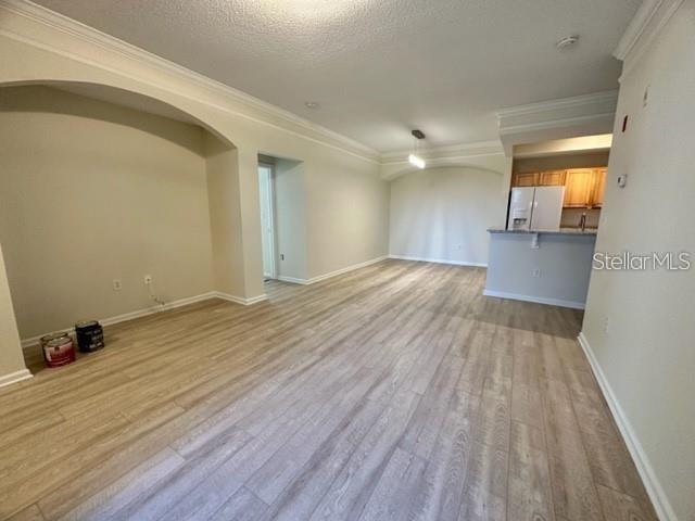 An open-concept living area features light wood-look flooring and an adjacent kitchen with light cabinetry — 12220 WILD IRIS WAY UNIT 108, ORLANDO, FL