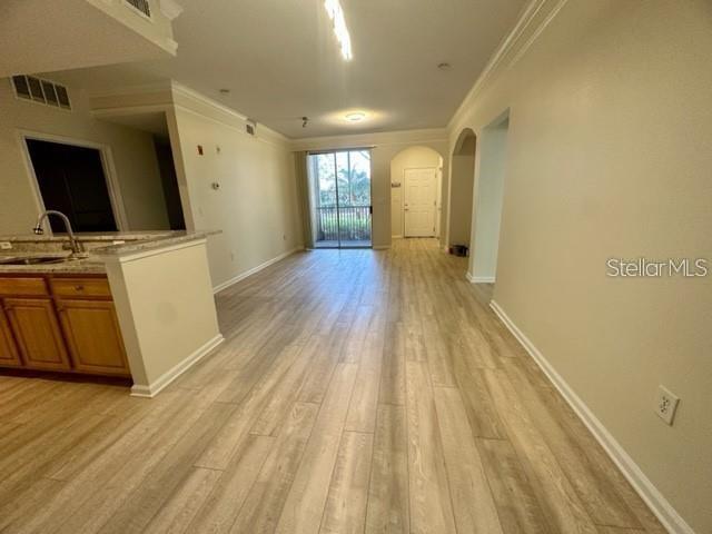 An open-concept living area features light wood-look flooring and a kitchen with wooden cabinets — 12220 WILD IRIS WAY UNIT 108, ORLANDO, FL