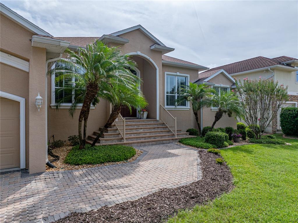 A single-story house with a beige stucco exterior, a two-car garage, and a paved driveway — 11972 W RIVERHAVEN DRIVE, HOMOSASSA, FL