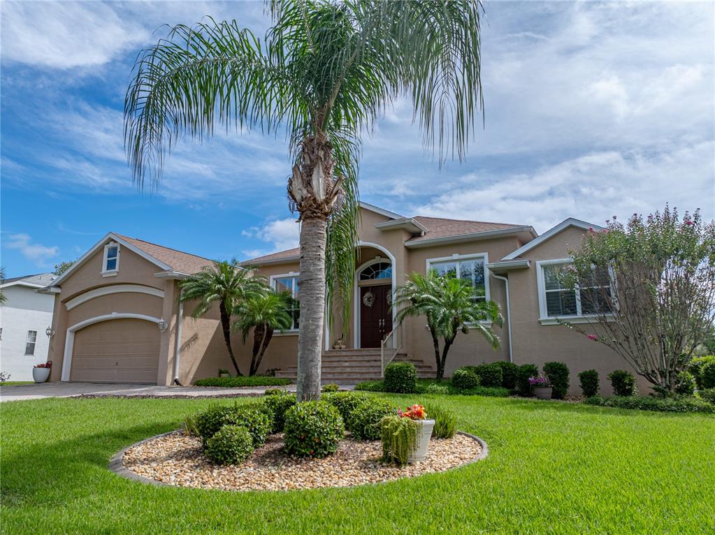 A tan, single-story suburban house features a palm tree in the front yard landscaping — 11972 W RIVERHAVEN DRIVE, HOMOSASSA, FL