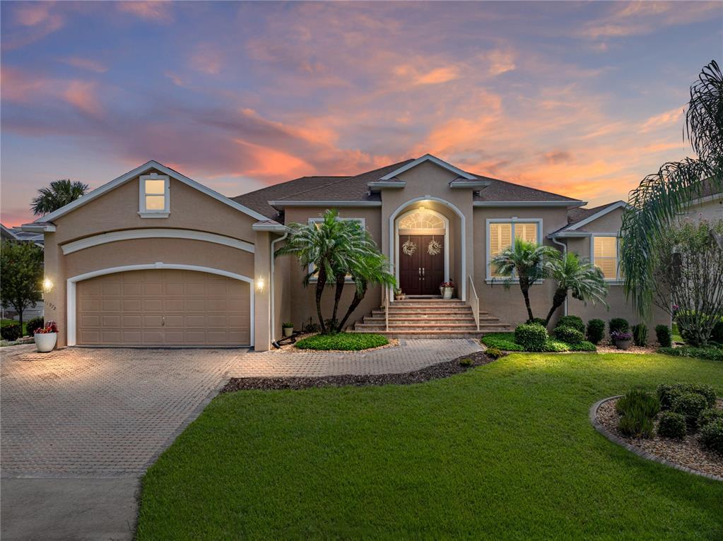 A tan house with a paved walkway, front steps, and palm trees in the yard — 11972 W RIVERHAVEN DRIVE, HOMOSASSA, FL