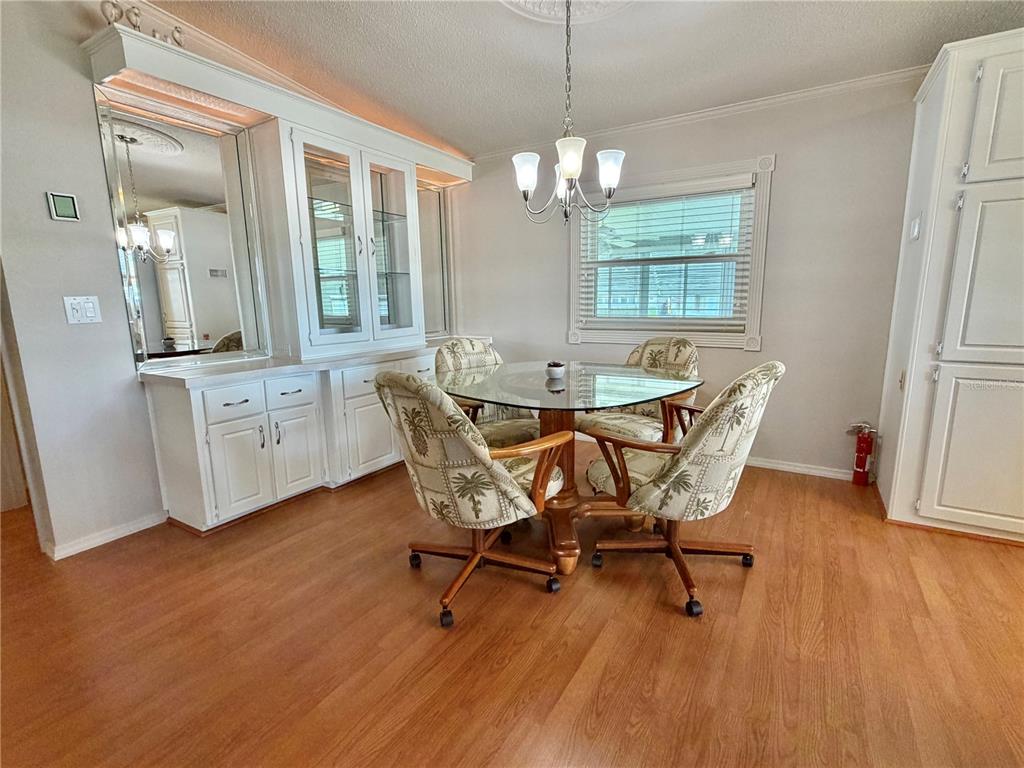 A dining room features a glass-topped table, four patterned chairs, and built-in white cabinetry — 303 HAWTHORNE BOULEVARD, LEESBURG, FL