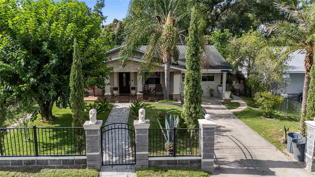 A single-story house with a stone-accented porch, gated walkway, and a paved driveway — 37253 SAFARI DRIVE, DADE CITY, FL