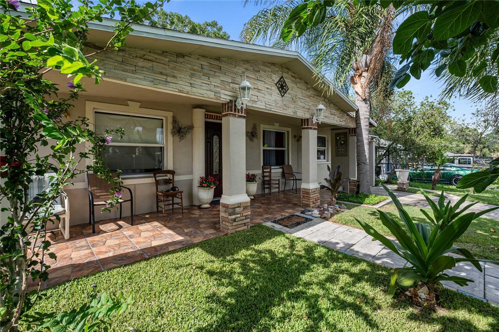 A front porch with stone accents, tiled flooring, and columns leads to the home entrance — 37253 SAFARI DRIVE, DADE CITY, FL