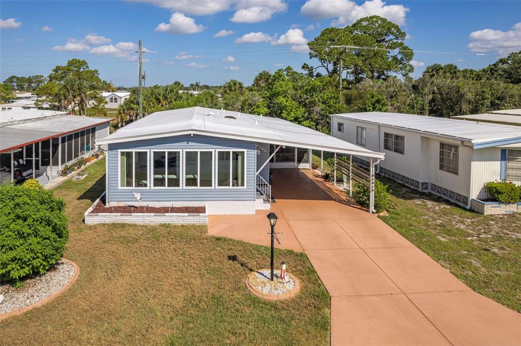 A blue mobile home with a white roof and a long concrete driveway — 240 LA COSTA, NORTH PORT, FL