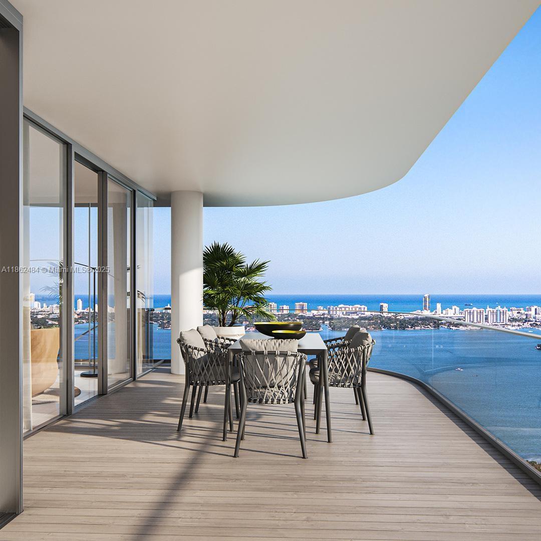 This is a rendering of a modern balcony with outdoor dining furniture overlooking the ocean — 700 NE 24th Street, Miami FL 33137, MIAMI, FL